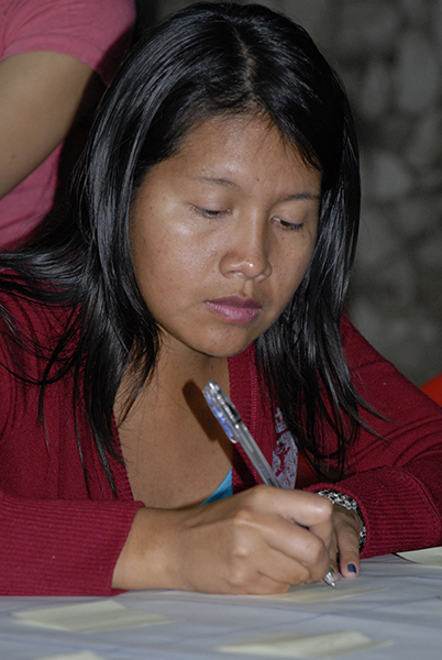 A person writing on a piece of paper with a pen