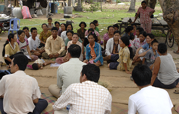 A group of people from a village in Cambodia sat on the floor having a meeting