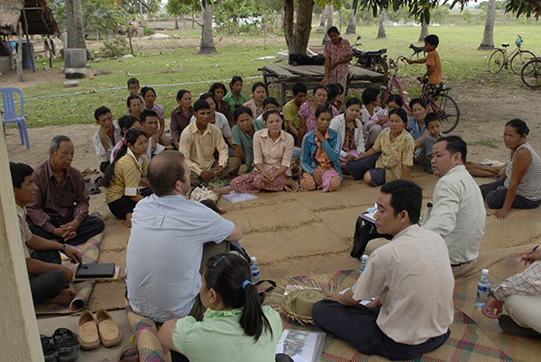 People from a village in Cambodia sat on the floor with a person running a focus group