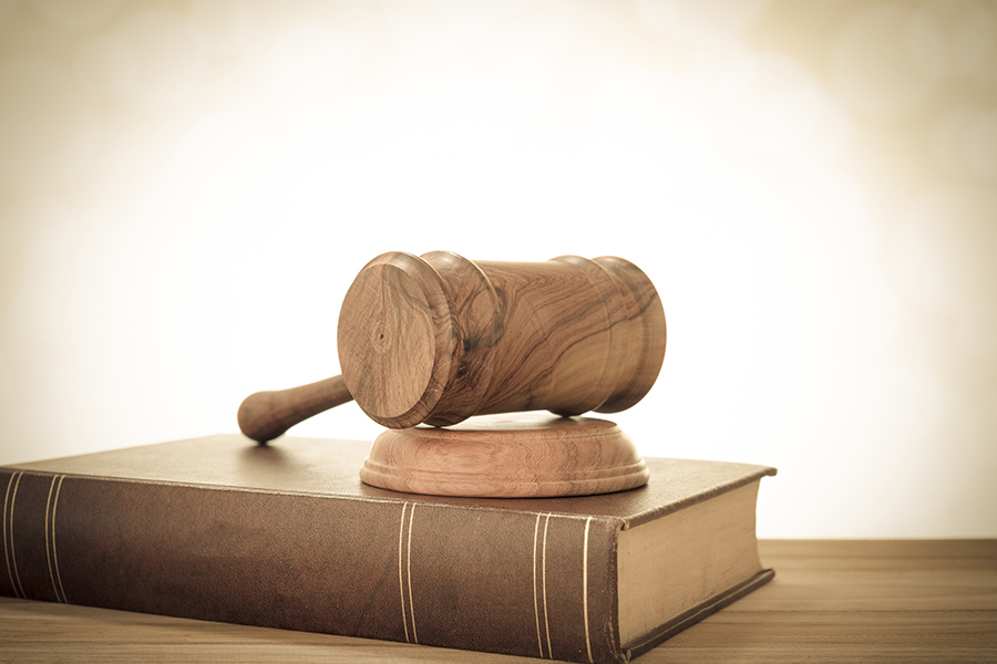 A gavel laying on top of a book.