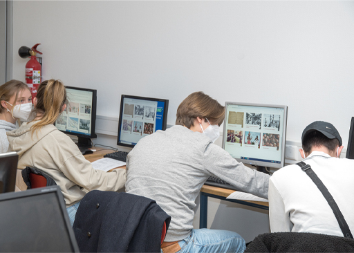 Studenten zitten aan bureaus met computers en kijken naar de website van RETOPEA.