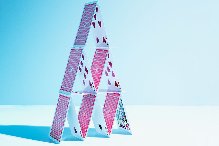 A decorative image depicting playing cards stacked one on top of each other to form a triangular pyramid.