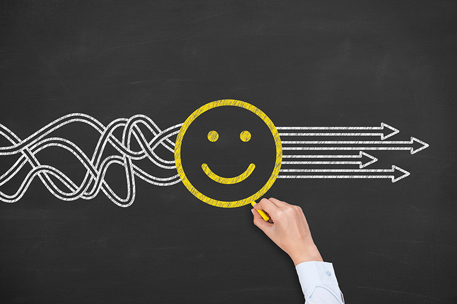 An illustration of tangled lines on the left-hand side which go into a circular smiley face. When the lines come out on the right-hand side of the face, they become straight arrows.