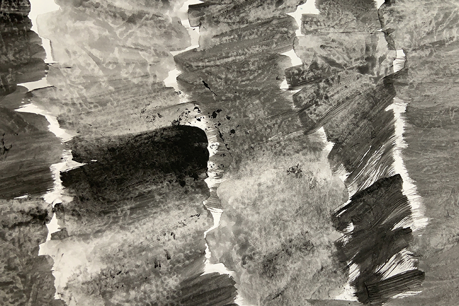 An oblique abstract image of random brushstrokes in tones of grey.