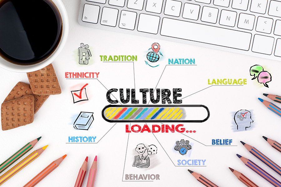 An image with the words culture loading at its centre. Around this are the words nation, language, belief, society, behaviour, history, ethnicity, and tradition. There are also some drawings of pencils, biscuits, a cup of coffee, and a computer keyboard.