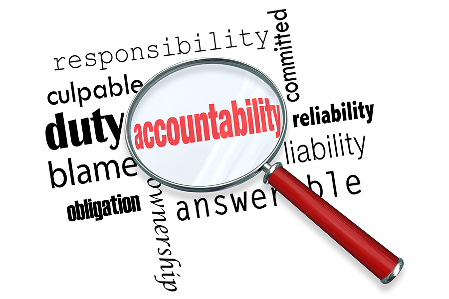 An image of a magnifying glass over the top of a word cloud. The word in focus is accountability.