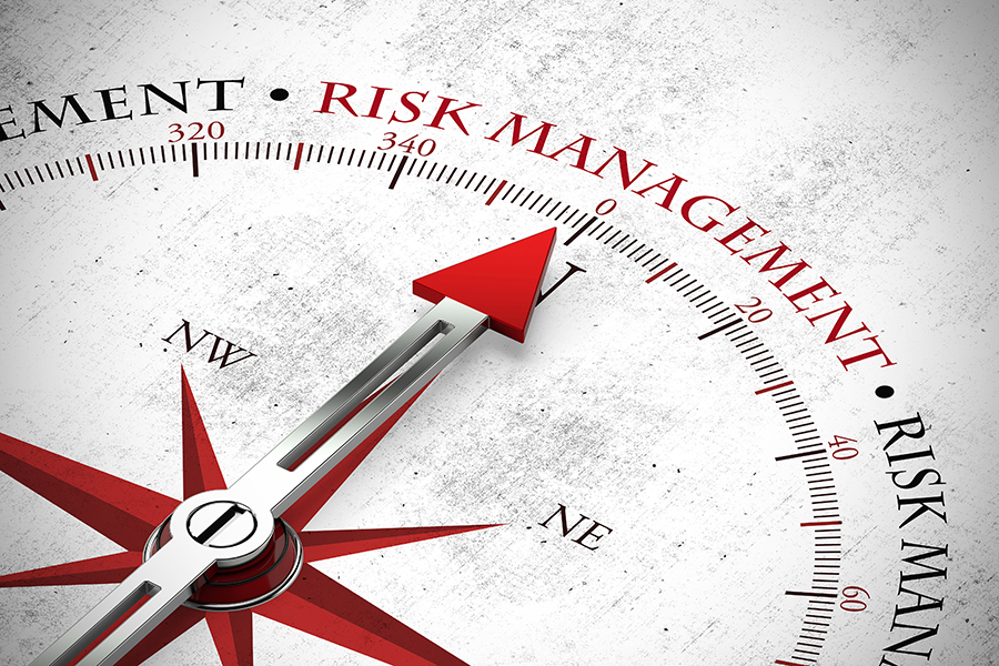 An image of a compass with the compass needle pointing towards the words risk management.