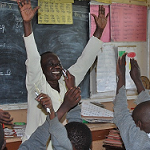 teacher holding up hands in a classroom