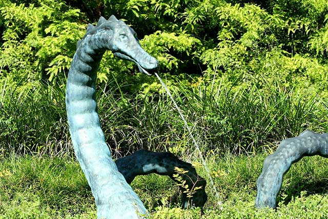 Green copper dragon scupture with water pouring from mourth.
