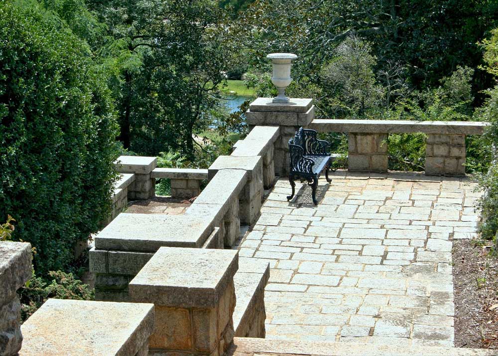 Flagstone garden terrace surrounded by low walls and overlooking the gardens below.