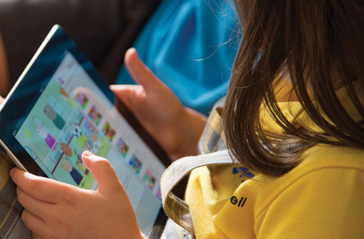 This is a photograph of a child using a tablet.