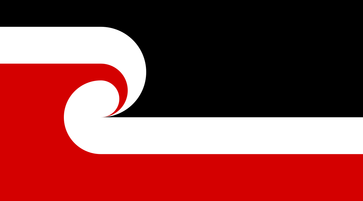 A flag in black, red ochre, and white. The main symbol is a fern frond, a common design in Māori tattoo and sculpture.