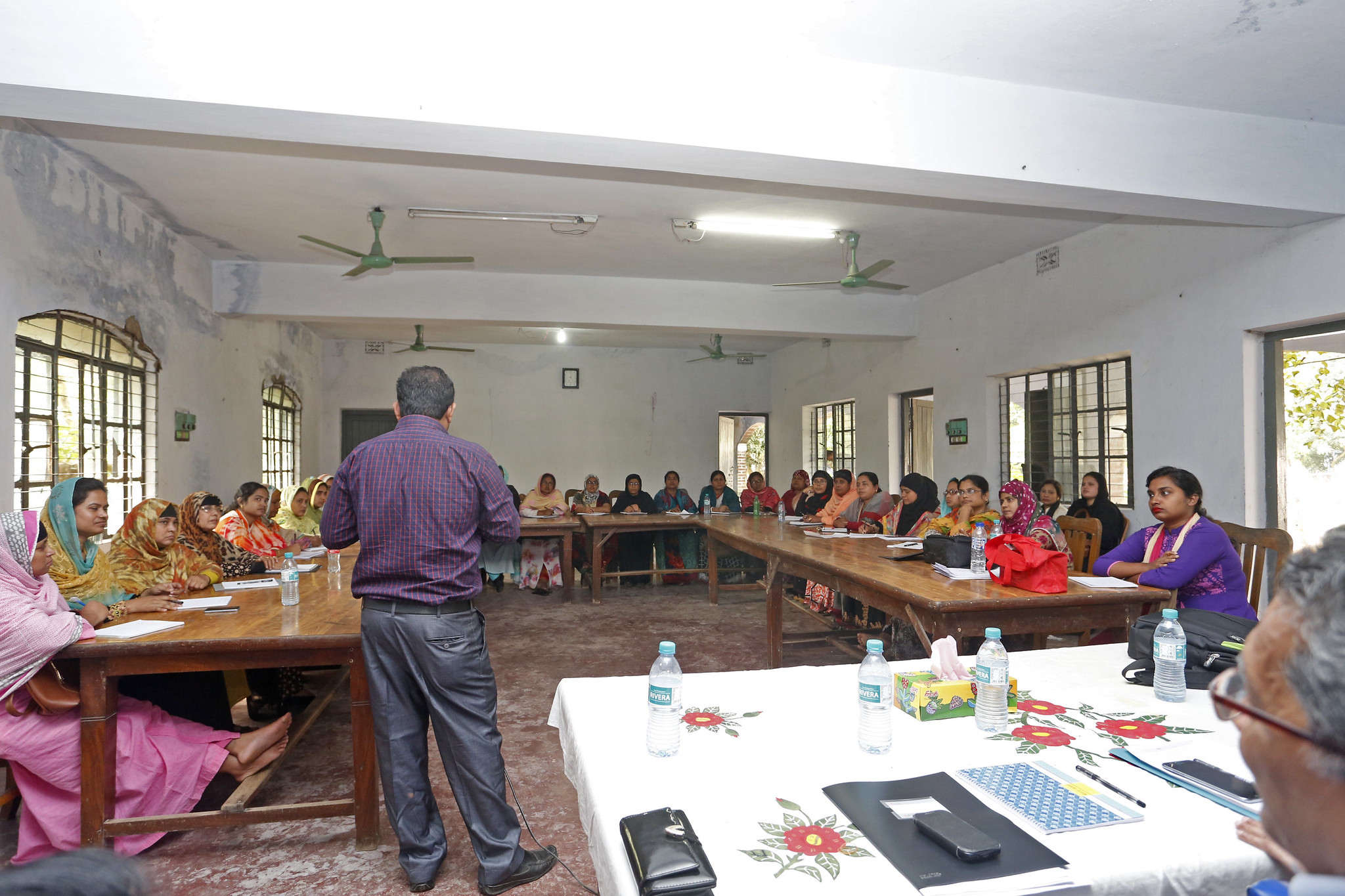Photograph of a classroom with a male teacher and female students. 