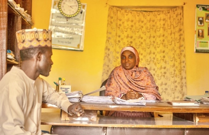 A male teacher and a female headteacher sitting at a desk