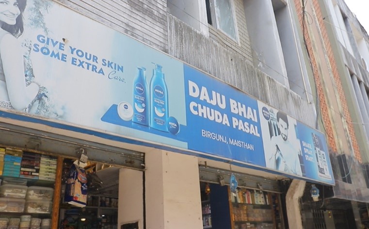 A sign above a shop in Nepal with English words and local language in the advertising