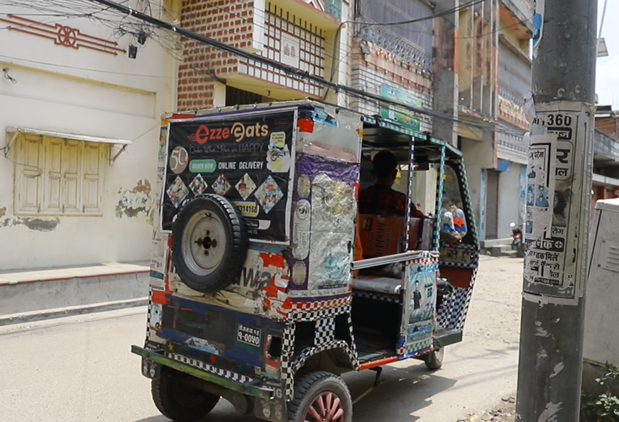 A tuk tuk in the street with stickers on it in different languages