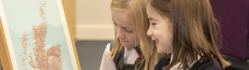 Two girls looking at a map of Scotland