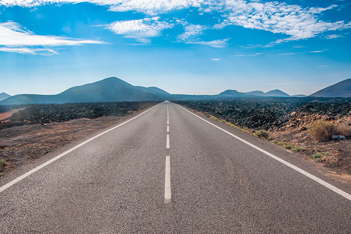A long straight road disappears towards the horizon in the distance.