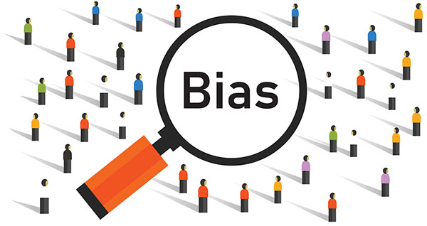 A cartoon of a crowd of people standing in lines looking towards the top right of the picture. In the middle is a magnifying glass with the word ‘Bias’ in the centre of the glass.