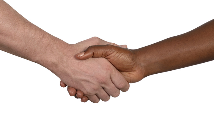 A picture of a close-up of two hands shaking in a gesture of agreement or partnership.