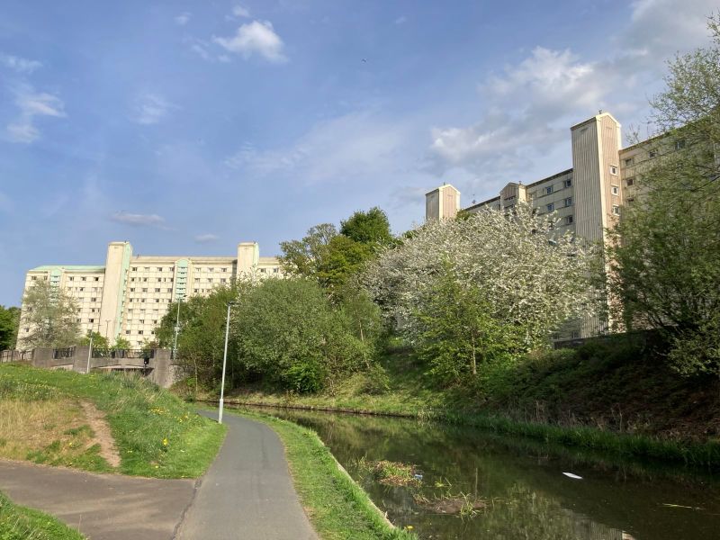 A high-rise local authority estate, looking down on a tree-lined canal