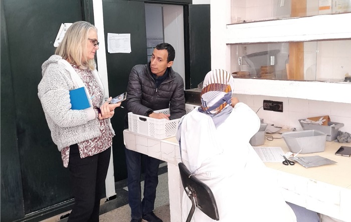 The image shows Janny van Beem working on quality management systems with scientists at a national agricultural research center. Check out the video transcript for more detailed video content.