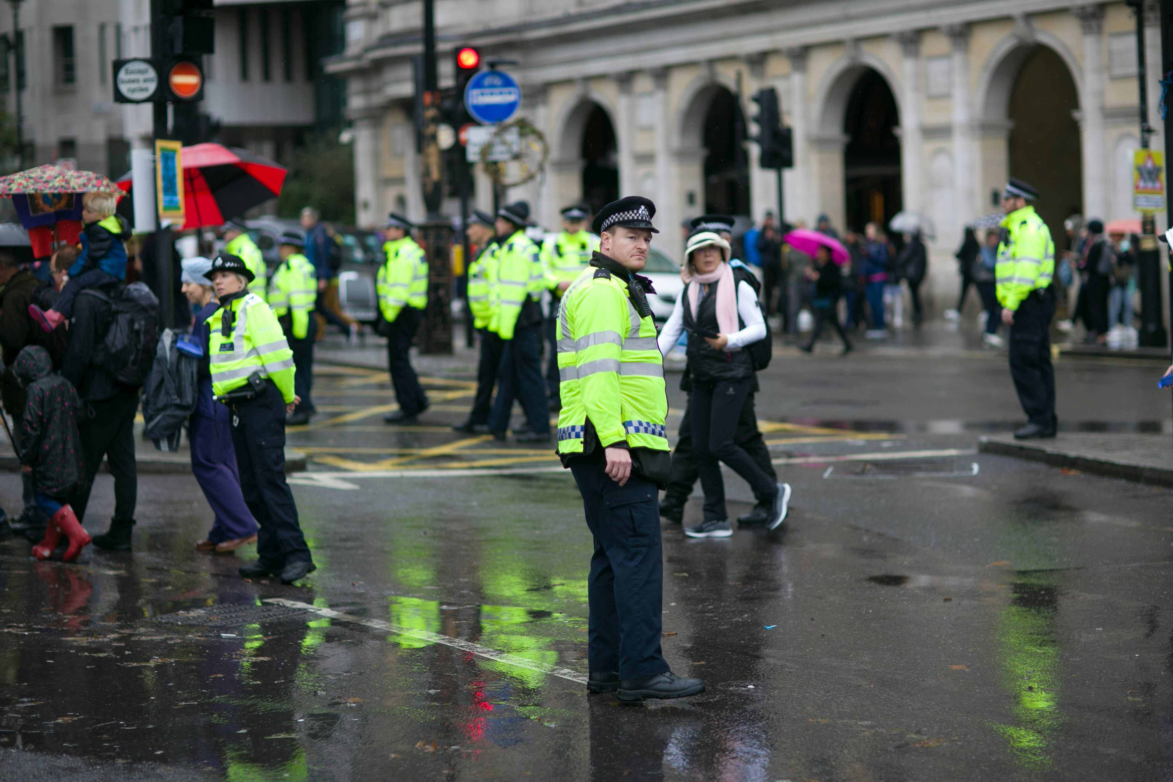 A number of police officers in full uniform stood on a busy city street