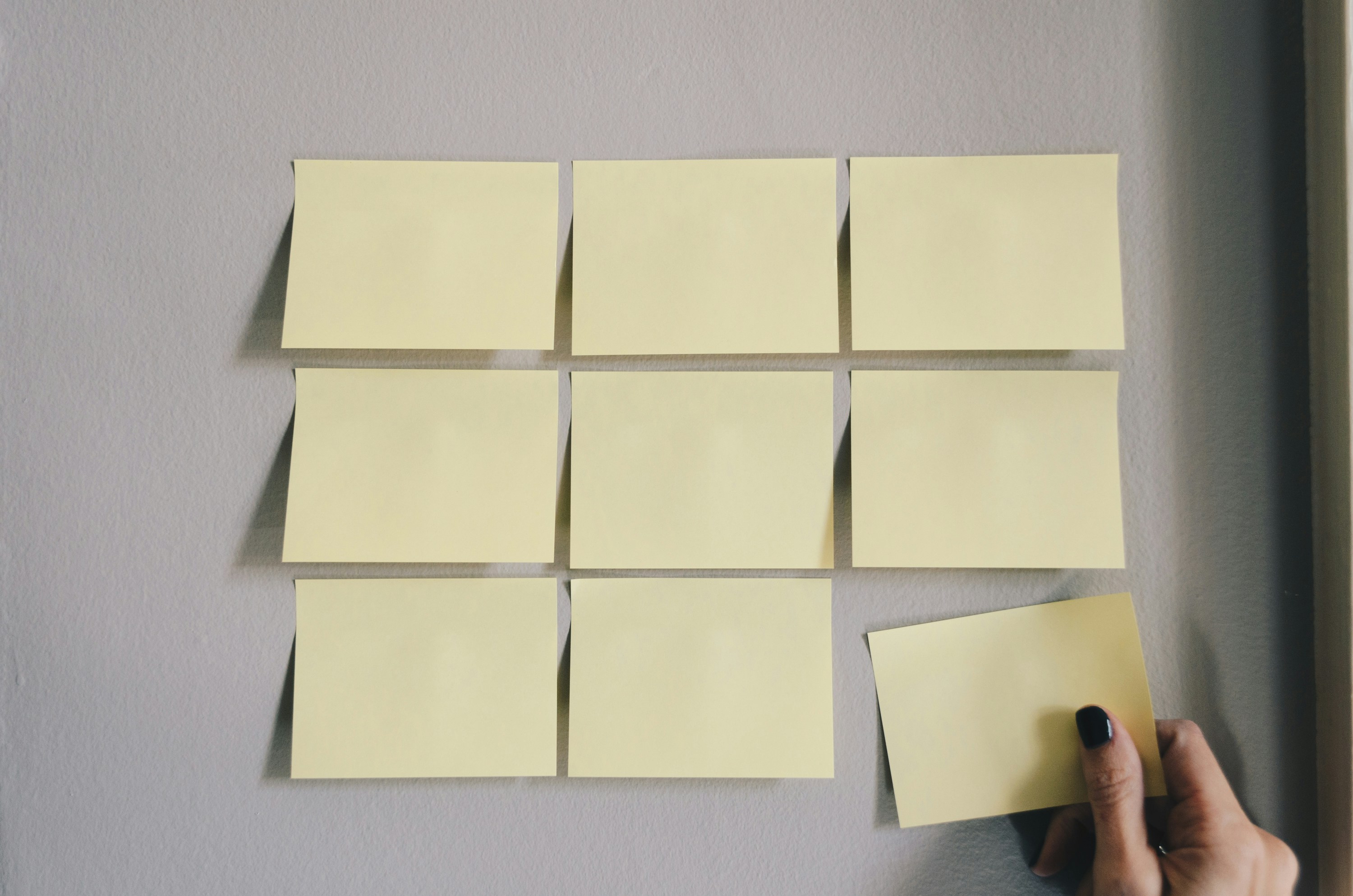 A set of 9 yellow Post it notes arranged in a grid style to show a planning process