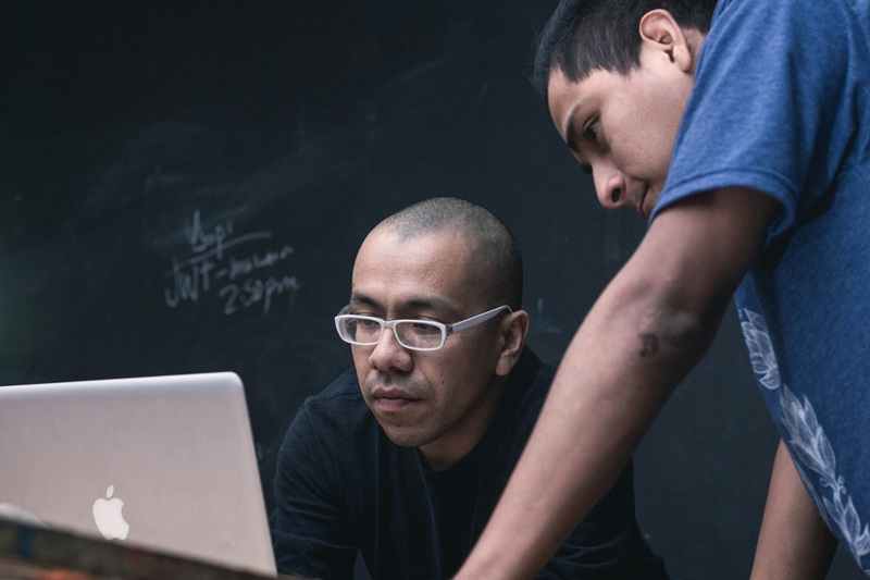 Two men looking at content on silver MacBook