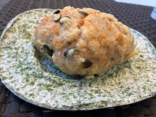 a bun placed on a algae-based plate, that is white and speckled with green