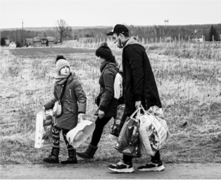 Refugees walking along a road carrying their belongings