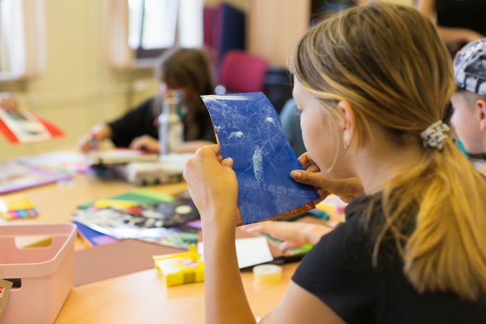 A young girl working at a school desk.