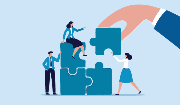 An illustration of three people assembling large puzzle pieces together, while a giant hand places an additional puzzle piece in place.