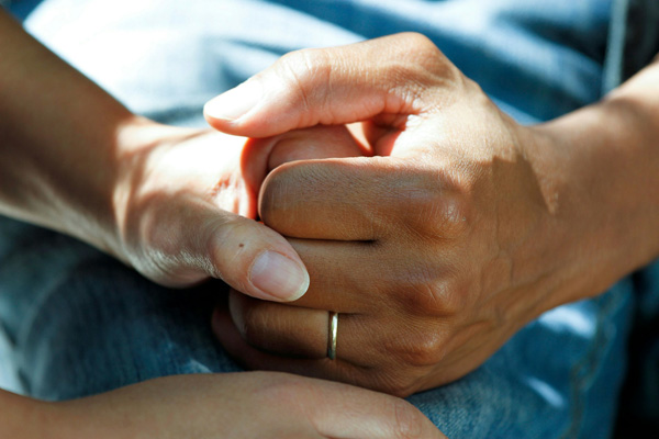 A photo of two hands held together in a supporting manner.