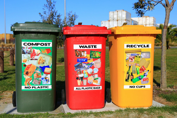 A photo of three waste bins for compost, waste and recycling.